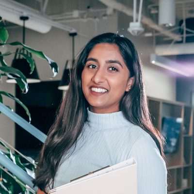 Happy young graduate holding a laptop
